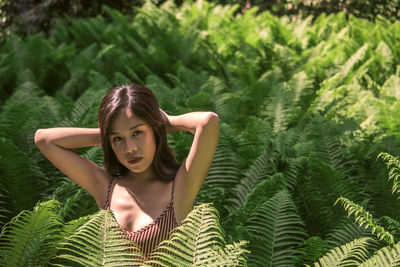 Portrait of young woman against plants