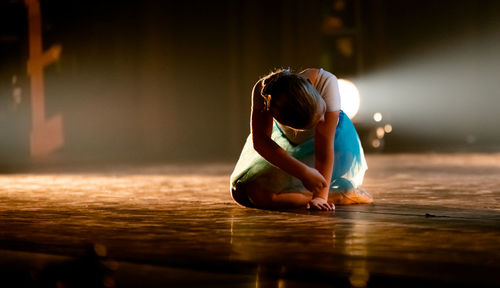 Woman sitting on wooden floor