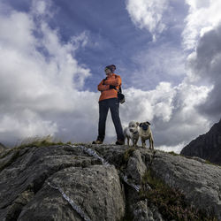 Dog standing on rock against sky