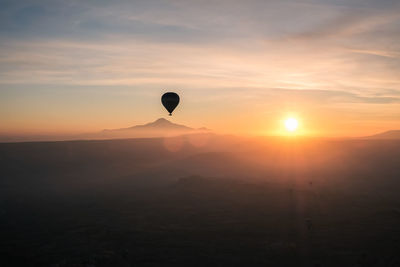 Hot air balloons flying against sky during sunset