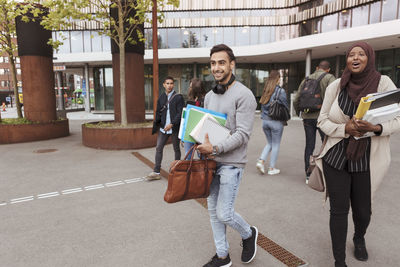 University students with books walking at campus