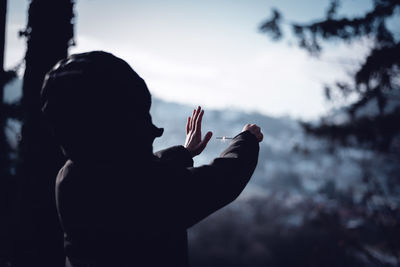 Rear view of silhouette man standing against sky