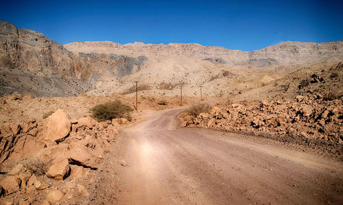 Road passing through desert against sky