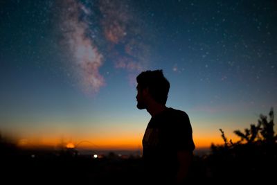 Low angle view of silhouette man standing against sky during sunset