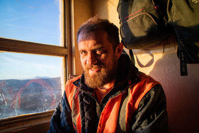 Portrait of senior man looking through window