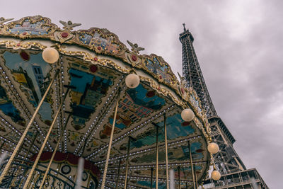 Low angle view of ferris wheel against cloudy sky