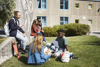 University students talking while sitting at campus