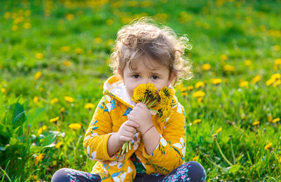 Portrait of boy blowing flowers