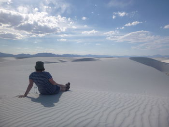 Rear view of woman relaxing at desert