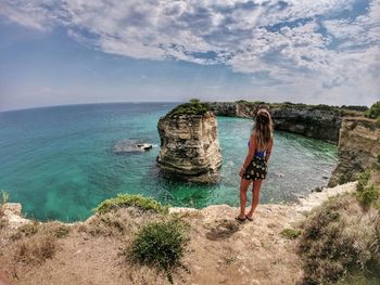 Rear view of woman looking at sea against sky