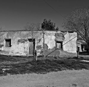 Abandoned house on field against sky