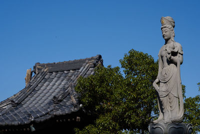 Statue of angel against clear blue sky