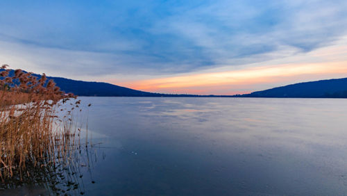 Scenic view of lake against sky during sunset