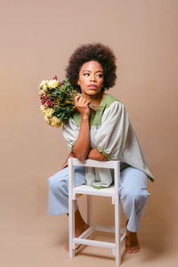 Portrait of young woman sitting on sofa