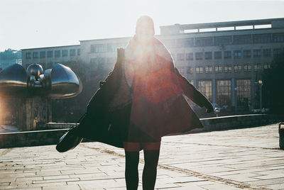 Rear view of woman in front of buildings