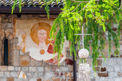 Statue of buddha against brick wall
