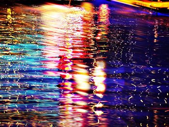 Reflection of illuminated lights in puddle