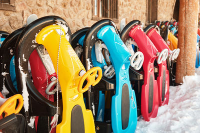 Row of colorful sleds to rent at ski resort. snow sleighs. winter leisure activities