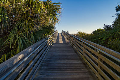 Surface level of footbridge against clear sky