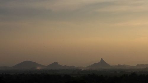 Scenic view of silhouette mountains against sky at sunset