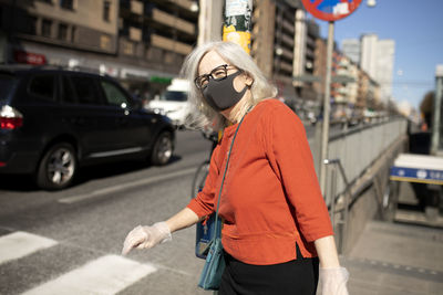 Woman wearing face mask while walking at street