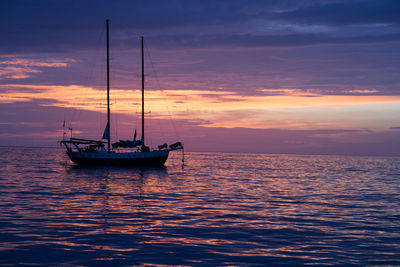 Boats in sea at sunset