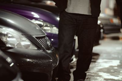 Low section of woman standing in car