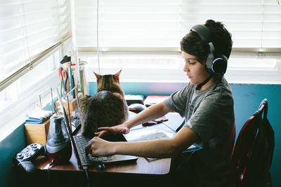 Side view of woman holding cat