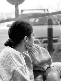 Rear view of girl looking through window