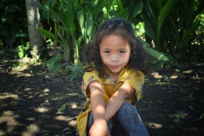 A cute little girl with curly hair on a leaf background