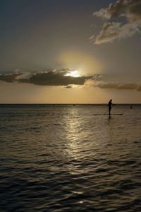 Silhouette person boating in calm sea