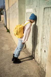 Woman in knit hat leaning on door during sunny day