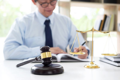 Lawyer doing paperwork while sitting at desk in courtroom