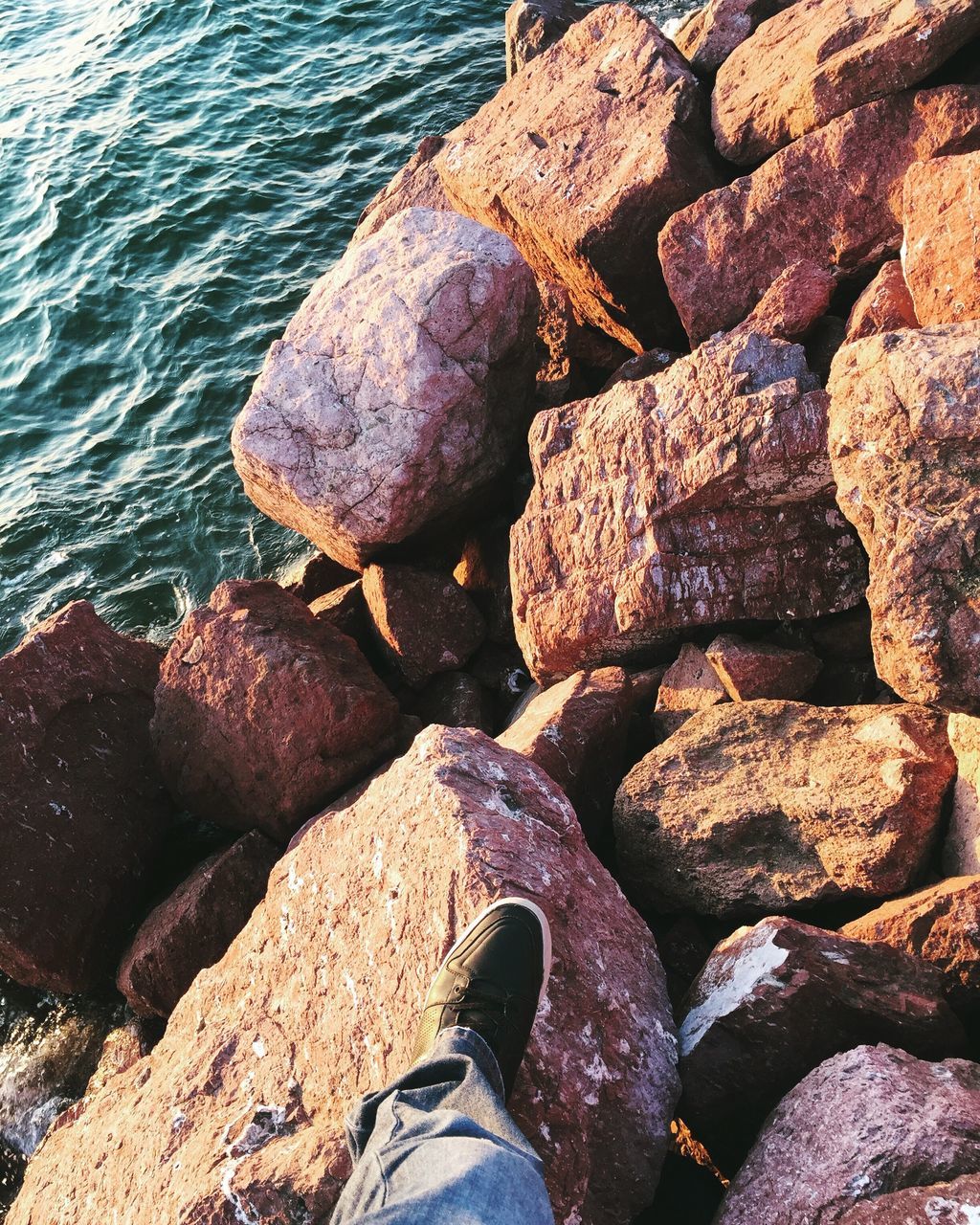 water, low section, person, rock - object, sea, standing, stone - object, personal perspective, high angle view, lifestyles, beach, men, leisure activity, nature, shore, shoe, human foot