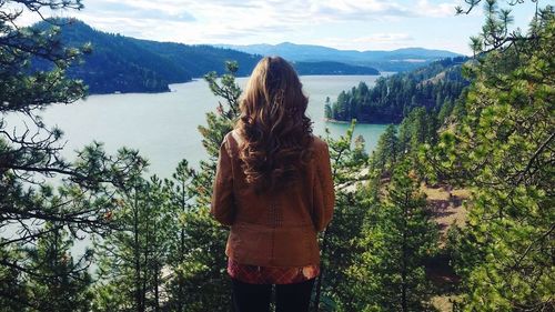 Woman in front of trees and river