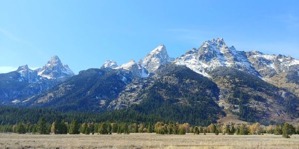 Scenic view of snowcapped mountains against blue sky