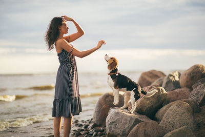 Man with dog standing on beach