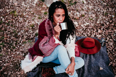 Young woman using mobile phone sitting outdoors