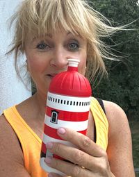 Close-up portrait of woman holding red bottle