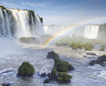 Scenic view of waterfall with rainbow