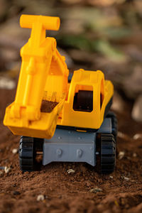 Close-up of yellow toy car on field