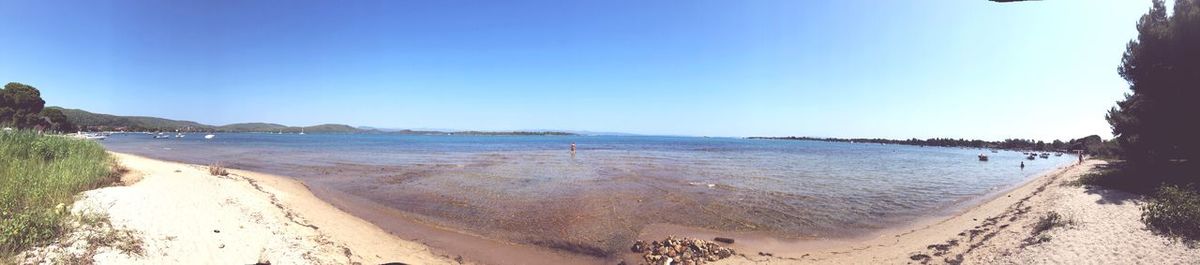 Panoramic view of beach against clear blue sky