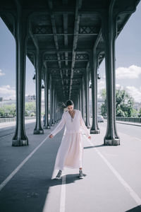 Rear view of woman standing on bridge