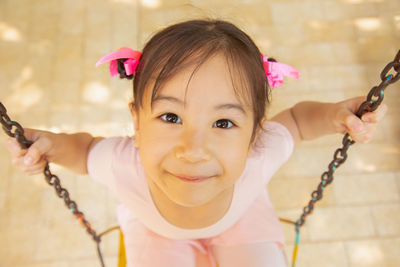 Portrait of cute girl swinging outdoors