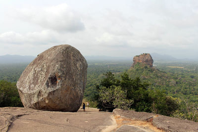 Rock formations on landscape against cloudy sky