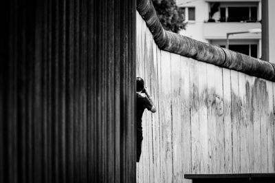 Person by surrounding wall in city