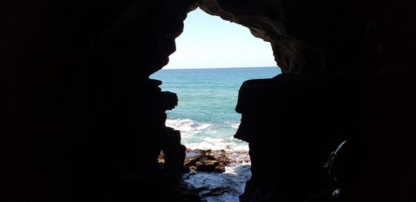 Scenic view of sea seen through cave