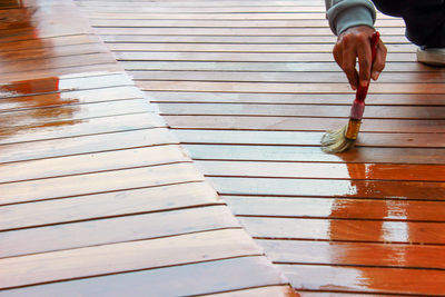 Low section of woman standing on boardwalk