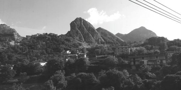 Panoramic shot of townscape and mountains against sky