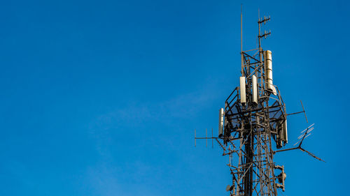 Mid shot of communications tower hosting various antennas and dishes